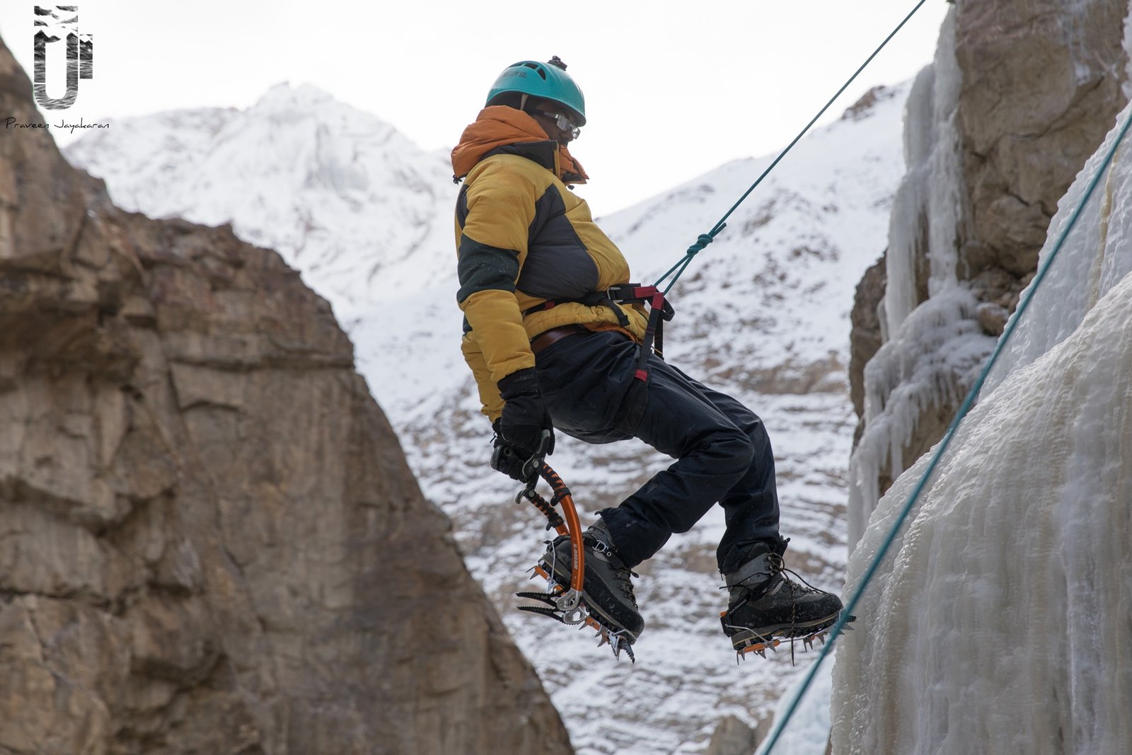 Ice climber rappelling from frozen waterfall, Spiti Valley